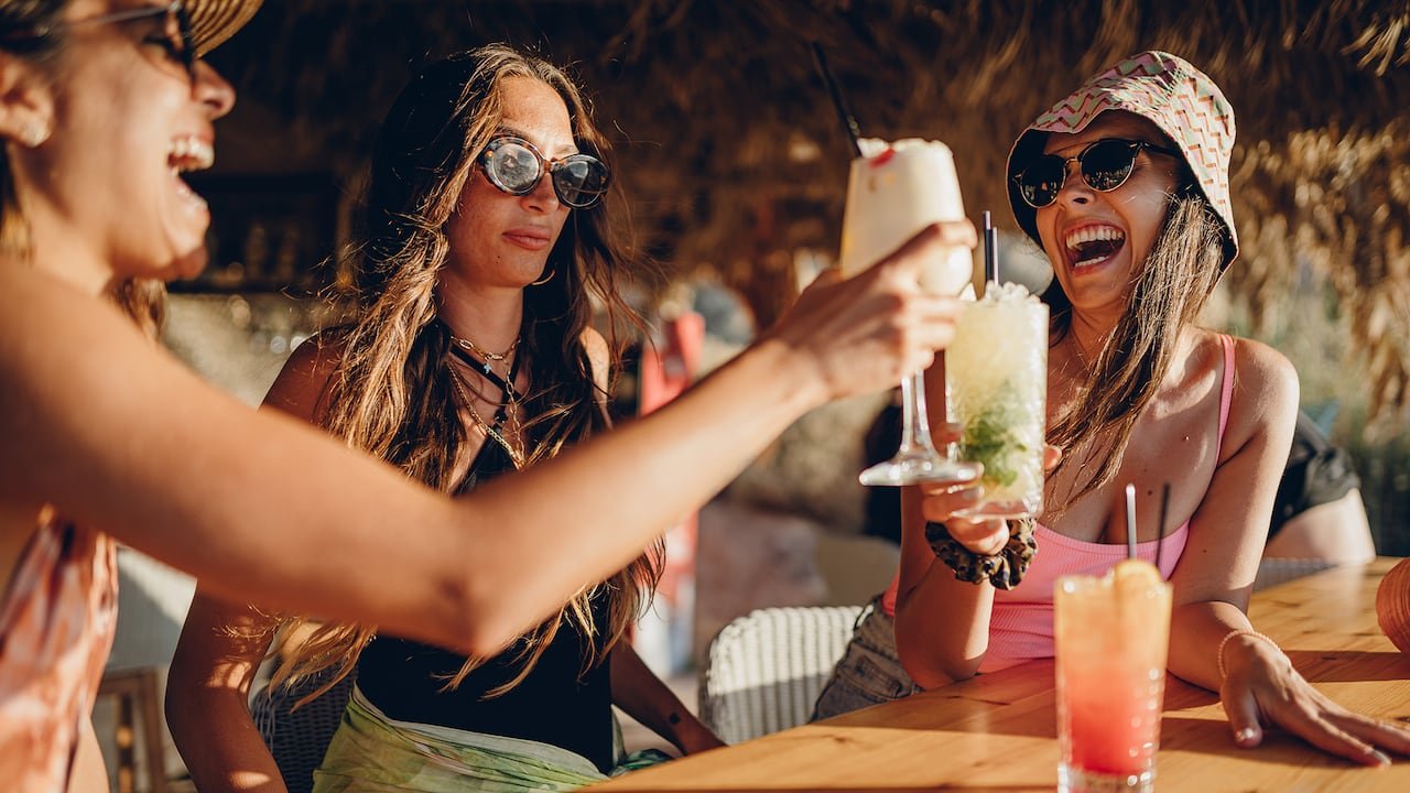 Friends at a beach bar with a woman looking concerned in the middle.