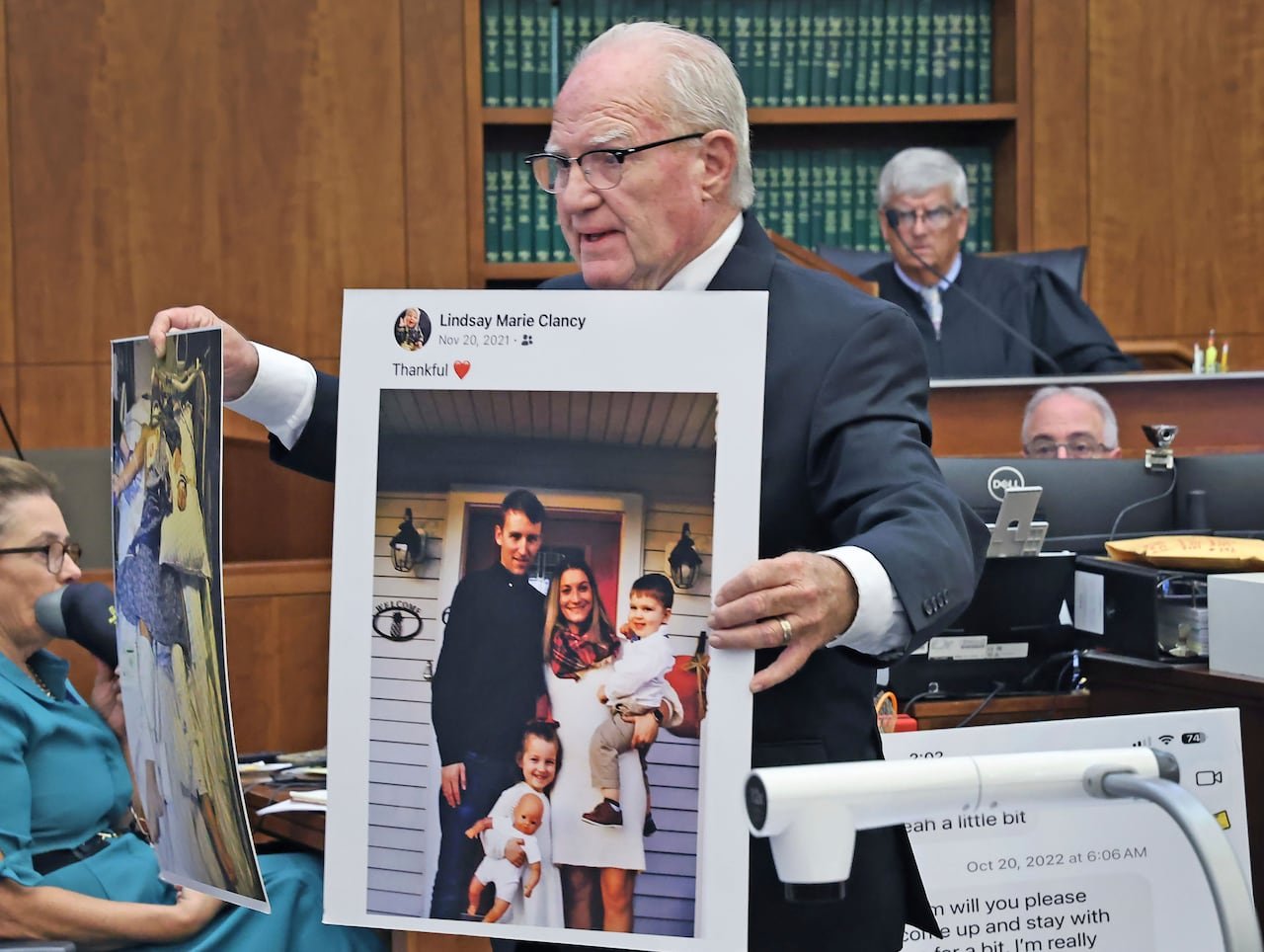 default-312 A man in a courtroom holds up a large photos of a smiling family